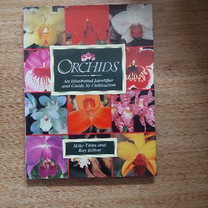 Book cover with colorful orchid images on a wooden surface