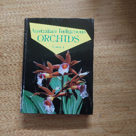 Book titled 'Australian Indigenous Orchids' on a wooden surface